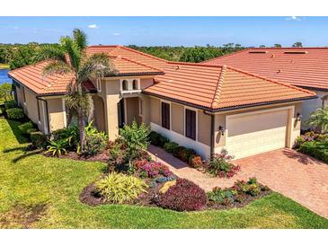 Beautiful exterior of a home with a terracotta roof, manicured lawn, and brick paver walkway at 23494 Copperleaf Dr, Venice, FL 34293