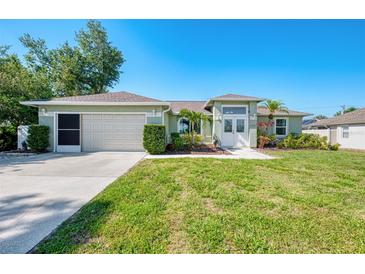 Charming single-story home with well-manicured lawn and tropical landscaping at 23516 Peachland Blvd, Port Charlotte, FL 33954