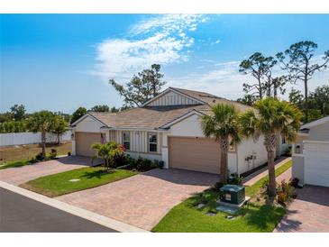 Inviting single-story home with a brick driveway and lush landscaping at 268 Ibiza Loop, Venice, FL 34292