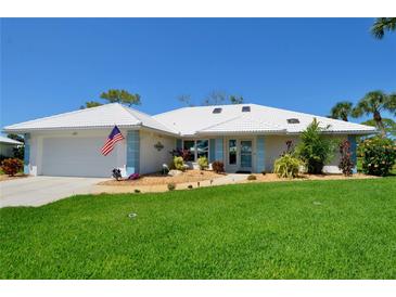 Charming single-story home boasting a well-manicured lawn, clean white tiled roof, and a welcoming two-car garage at 611 Paget Dr, Venice, FL 34293