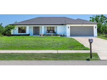 Charming single-story home featuring a well-manicured lawn, two-car garage and covered front porch at 6126 Spinnaker Blvd, Englewood, FL 34224