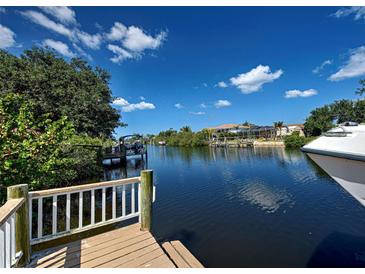 Scenic waterfront view featuring a private dock and canal access on a clear, sunny day at 617 Bonito Ave, Nokomis, FL 34275