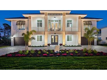 Stunning two-story home showcasing manicured landscaping, a brick driveway, and a charming front entrance at 9810 Eagle Preserve Dr, Englewood, FL 34224