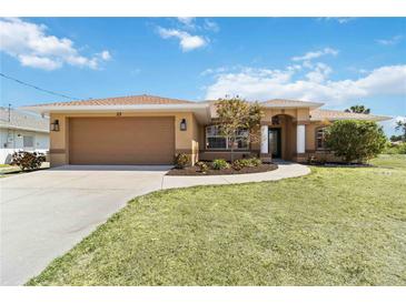 Charming single-story home with a two-car garage and manicured lawn at 113 Mark Twain Ln, Rotonda West, FL 33947