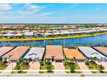 Waterfront home with barrel tile roof, and manicured landscaping at 13202 Borrego St, Venice, FL 34293