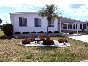 Charming home with well-maintained landscaping, featuring a lovely palm tree and manicured bushes at 175 Palm Harbor Dr, North Port, FL 34287