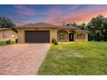 Charming single-story home featuring a brick driveway and well-maintained lawn at 431 Sevilla St, North Port, FL 34287