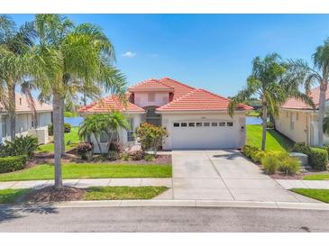 Charming home featuring a barrel tile roof, two-car garage, and a beautifully landscaped front yard at 4427 Blue Heron Cir, North Port, FL 34287