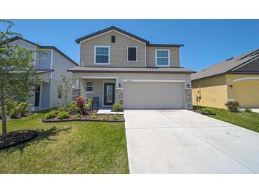 Charming two-story home featuring a well-manicured lawn and a spacious two car garage at 4523 Birdsong Dr, Palmetto, FL 34221