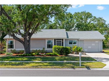 Charming single-story home with a well-manicured front yard, mature landscaping, and attached garage at 5457 Talbrook Rd, North Port, FL 34287