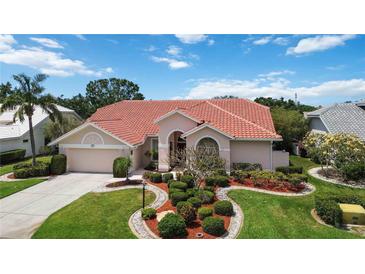 Charming single Gathering home featuring a lush landscaped yard and a classic red tile roof at 6507 Drewry'S Blf, Bradenton, FL 34203