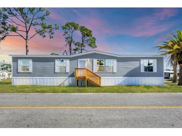 Charming single-story home featuring a well-maintained yard and neutral-colored siding at 6803 Amoko Ct, North Port, FL 34287