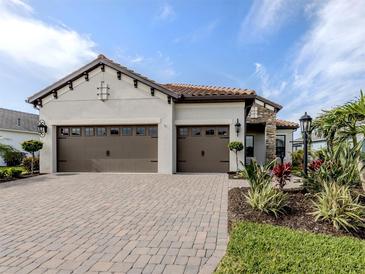 This home features a three-car garage and a brick paved drive at 10973 Trevino St, Englewood, FL 34223