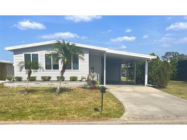 Charming home featuring well-manicured landscaping, a covered carport, and lovely curb appeal at 177 Palm Harbor Dr, North Port, FL 34287