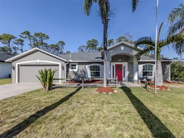 Charming single-story home with a gray exterior, well-manicured lawn, and vibrant pink front door at 3255 Tally Ho Rd # 1, North Port, FL 34291