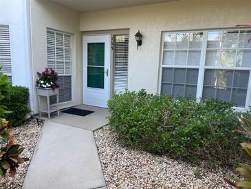 Inviting front entrance with a decorative planter, manicured landscaping, and a well-lit doorway at 406 Laurel Lake Dr # 103, Venice, FL 34292