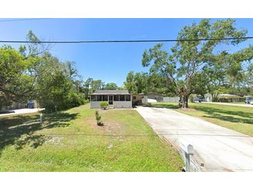 Charming single-story home with a screened porch and a well-manicured front yard at 5106 S Lockwood Ridge Rd, Sarasota, FL 34231