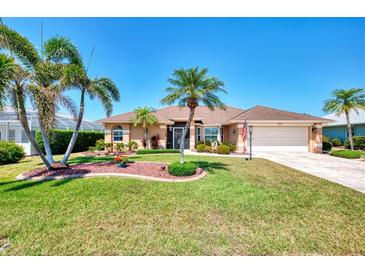 Charming single-story home boasts lush landscaping, palm trees, and a well-maintained lawn at 5868 Jefferson Rd, Venice, FL 34293