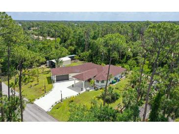 An aerial view of a home with a red roof surrounded by trees at 66 Statler St, Port Charlotte, FL 33954