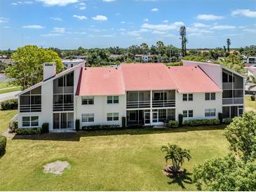 Well-maintained condo building features clean lines, lush lawn, and a distinctive red roof, embodying comfort and style at 770 Village Cir # 232, Venice, FL 34292