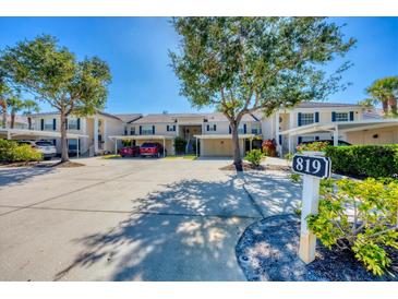 Charming condo exterior featuring carport, lush landscaping, and well-maintained grounds in a desirable community at 819 Montrose Dr # 102, Venice, FL 34293