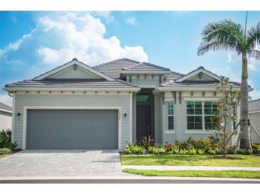 Charming single-story home features a gray exterior, well-manicured lawn, and a two-car garage at 12548 Wellen Golf St, Venice, FL 34293