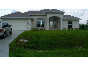 Charming one-story home featuring an attached garage and covered entryway with landscaped front yard at 1450 Yakutat Rd, North Port, FL 34287