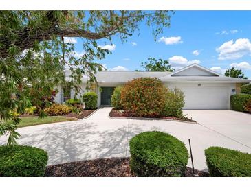 Well maintained single story home with mature landscaping, and a large driveway to the attached two car garage at 1833 Raintree Ln, Venice, FL 34293