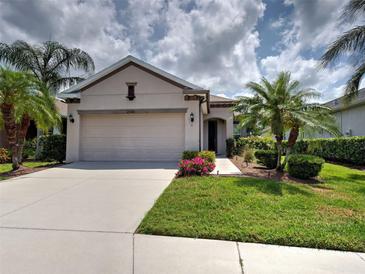 Charming single-story home with well-manicured lawn and mature palm trees at 25784 Grayton Ave, Englewood, FL 34223