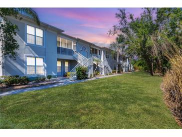 Low angle of a two-story condo with lawn, showing walkways and staircases at 2614 River Preserve Ct # 2614, Bradenton, FL 34208