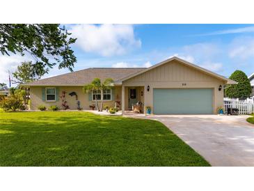Charming single-story home with a well-manicured lawn, blue shutters and a two-car garage at 30 Jamestown Ave, Englewood, FL 34223