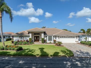 Stunning single-story home features manicured landscaping, a paver driveway, and a two-car garage at 314 Oakwood Cir, Englewood, FL 34223