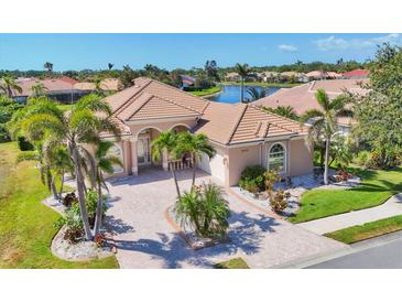 Beautiful single-Gathering home with a tile roof, arched entryway, palm trees, and brick driveway at 4403 Via Del Villetti Dr, Venice, FL 34293