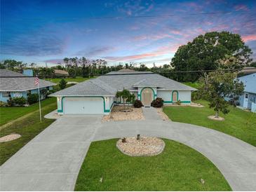 Charming single-story home featuring a circular driveway, lush landscaping, and a two-car garage, perfect for suburban living at 447 Rotonda Cir, Rotonda West, FL 33947