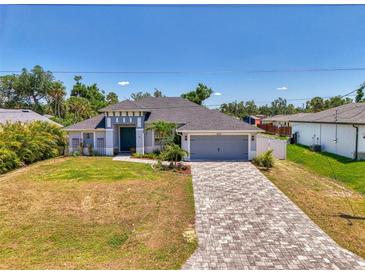 Beautiful single-Gathering home showcasing a long brick driveway, attached garage, and lovely landscaping at 4624 Caribou Ave, North Port, FL 34287