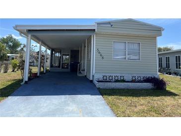 Charming single-story home featuring a covered carport and well-maintained lawn at 5668 Holiday Park Blvd, North Port, FL 34287