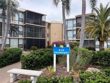 Exterior view of the Sandpiper condos with palm trees and lush landscaping at 618 Bird Bay S Dr # 212, Venice, FL 34285