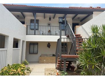 Charming courtyard view with stairs leading to second-story units and lovely landscaping at the entrance at 744 Avenida Estancia # 144, Venice, FL 34292