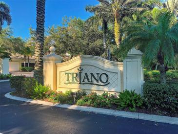 Elegant community entrance sign with lush landscaping and mature palm trees in a sunny setting at 212 Triano Cir # 212, Venice, FL 34292