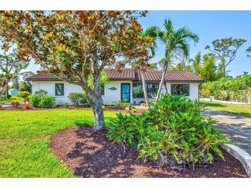 Charming single-story home with lush landscaping, mature trees, and a well-manicured lawn at 301 Gulf Dr, Venice, FL 34285