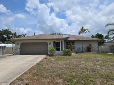 Charming single-story home featuring an attached garage, well-maintained lawn, and inviting front entrance at 3311 Papaya Rd, Venice, FL 34293