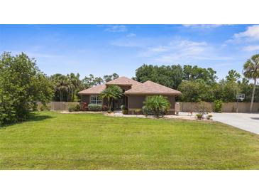Charming single-story home boasts a well-manicured lawn and tropical landscaping at 3950 Pepper Ln, North Port, FL 34287