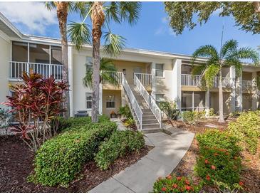 Inviting condo exterior featuring lush landscaping and screened balconies, a tropical oasis at 421 Cerromar Ter # 471, Venice, FL 34293
