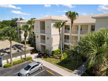 Beautiful condo building with lush tropical landscaping, a parking lot, and private balconies in a sunny, inviting setting at 600 Gardens Edge Dr # 613, Venice, FL 34285
