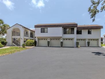 Well-maintained condo building with private garages and lush landscaping at 800 Capri Isles Blvd # 124, Venice, FL 34292