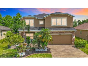 Two-story home featuring a beautifully landscaped front yard and a brick-paved driveway leading to a two-car garage at 9019 39Th Street Cir E, Parrish, FL 34219
