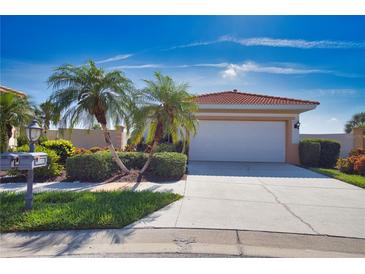 Charming home showcasing a well-manicured lawn, mature palm trees, and a pristine two-car garage at 102 Mestre Pl, North Venice, FL 34275
