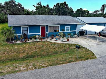 Charming blue single-story home with red front door and well-kept lawn with garage and boat parking at 1103 Lucille Ave, Nokomis, FL 34275