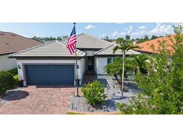 Charming single-story home featuring a manicured lawn, paver driveway, and neutral paint scheme at 1481 Hyssop Loop, North Port, FL 34289