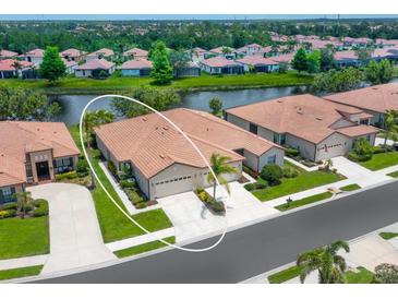 Charming attached villa with two-car garage, lush landscaping, and serene water views at 1493 Maseno Dr, Venice, FL 34292